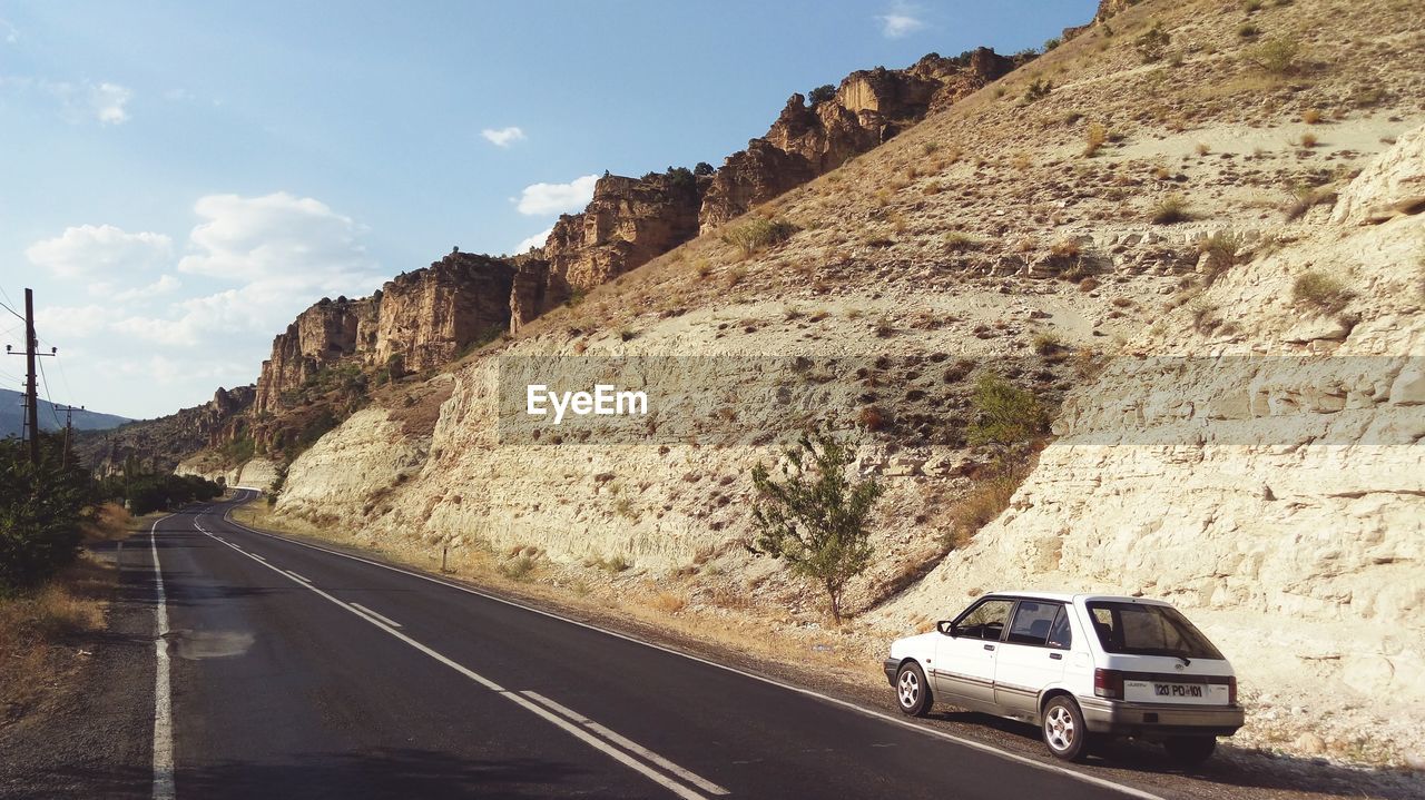 CARS ON ROAD BY ROCK FORMATIONS