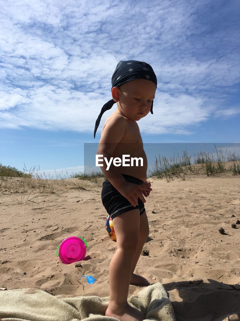 FULL LENGTH OF SHIRTLESS BOY ON SAND AT BEACH