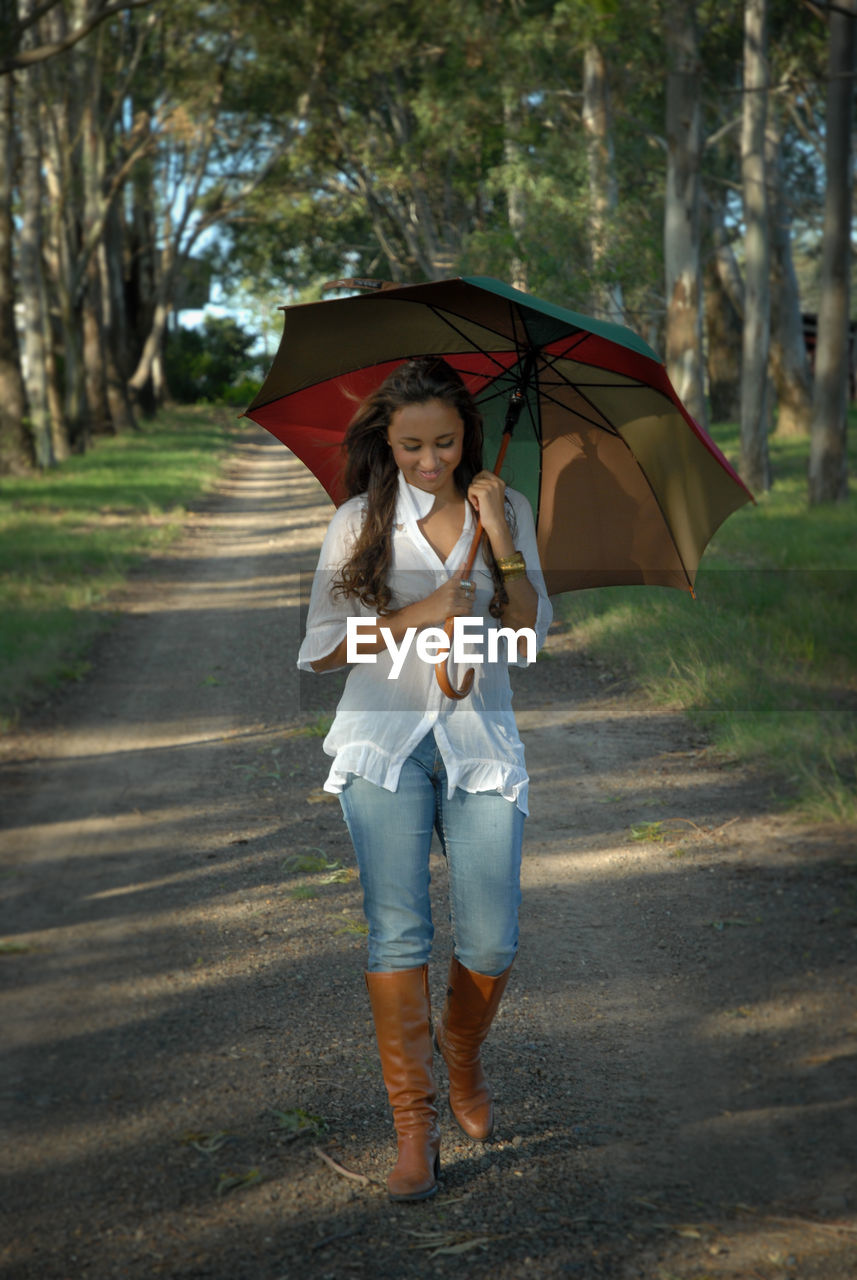 Full length of man holding umbrella walking in rain