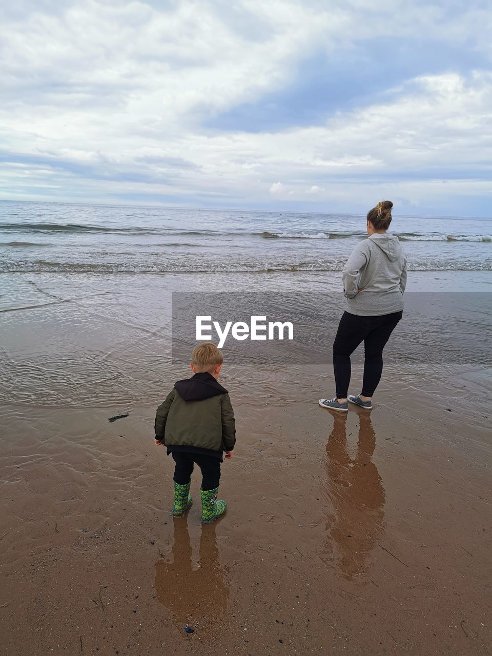 Mother and son looking into sea