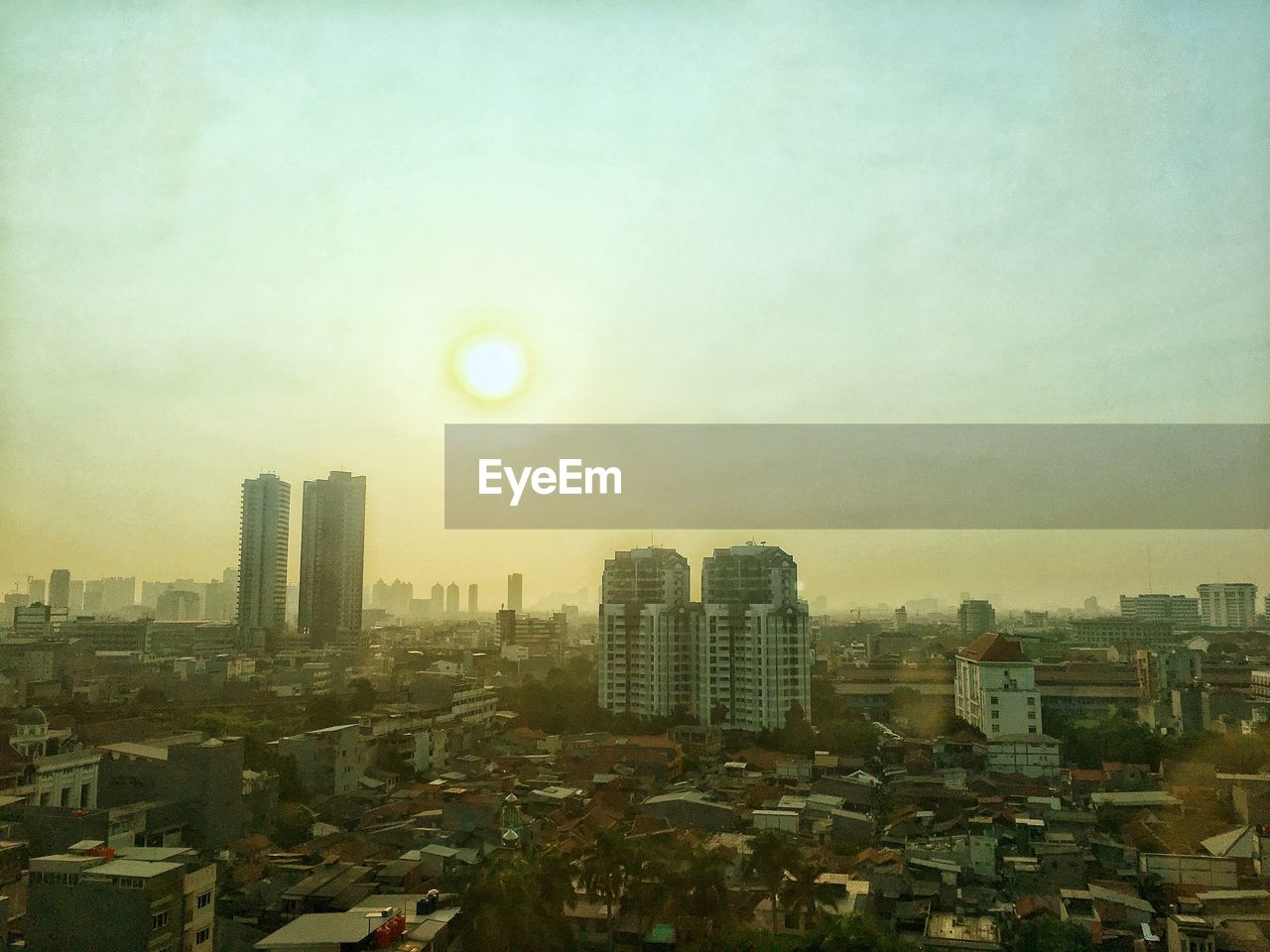 Buildings in city against sky during sunset