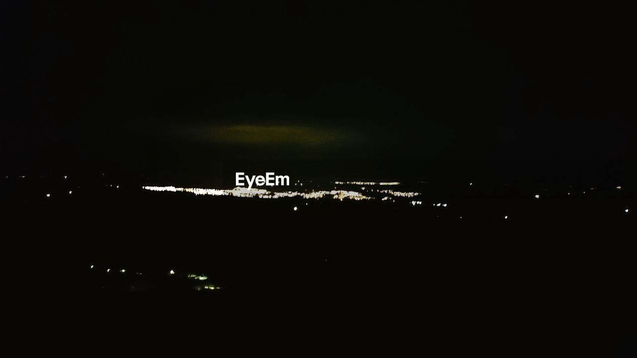 VIEW OF ILLUMINATED CITY AT NIGHT