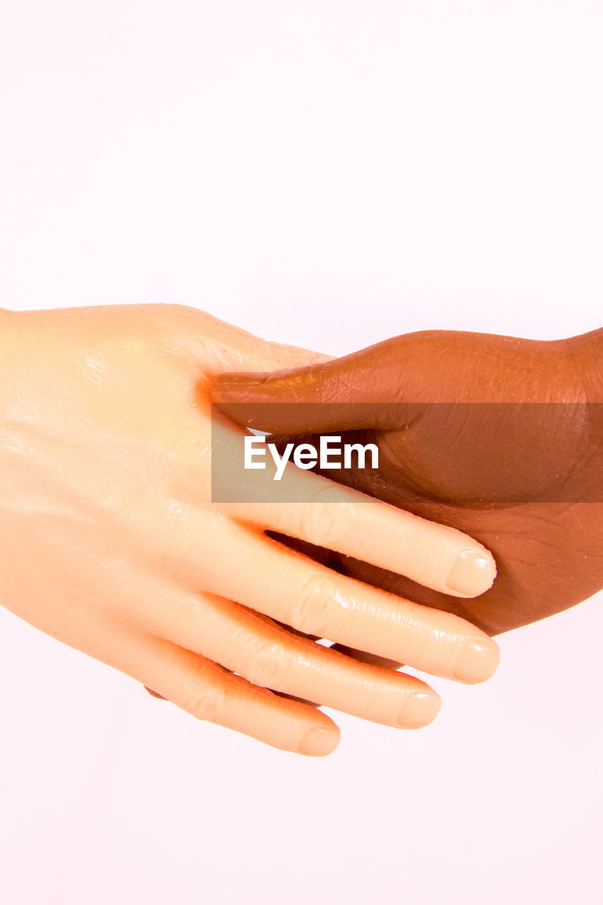 CLOSE-UP OF WOMAN HAND OVER WHITE BACKGROUND