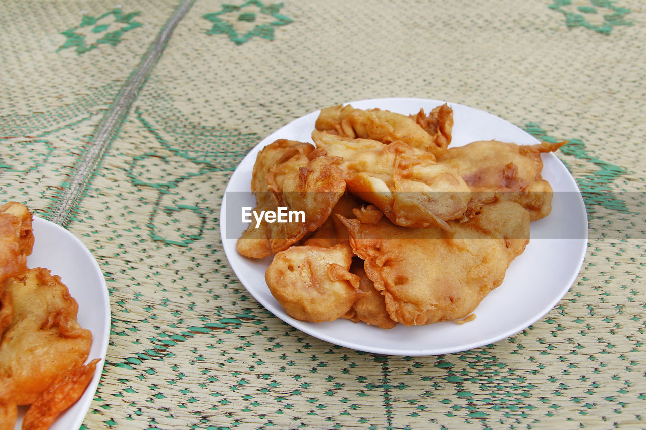 Pisang goreng or fried banana in a plate on the straw mat at yogyakarta, indonesia