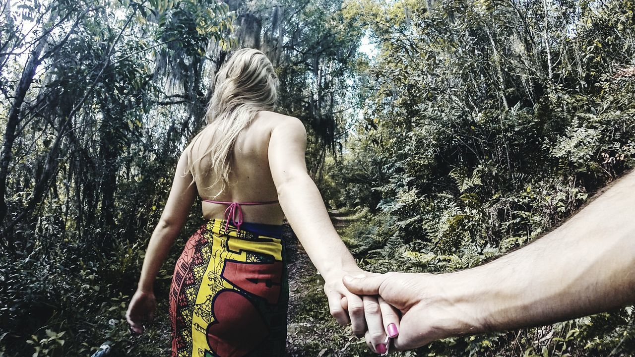 Man holding woman hand in forest