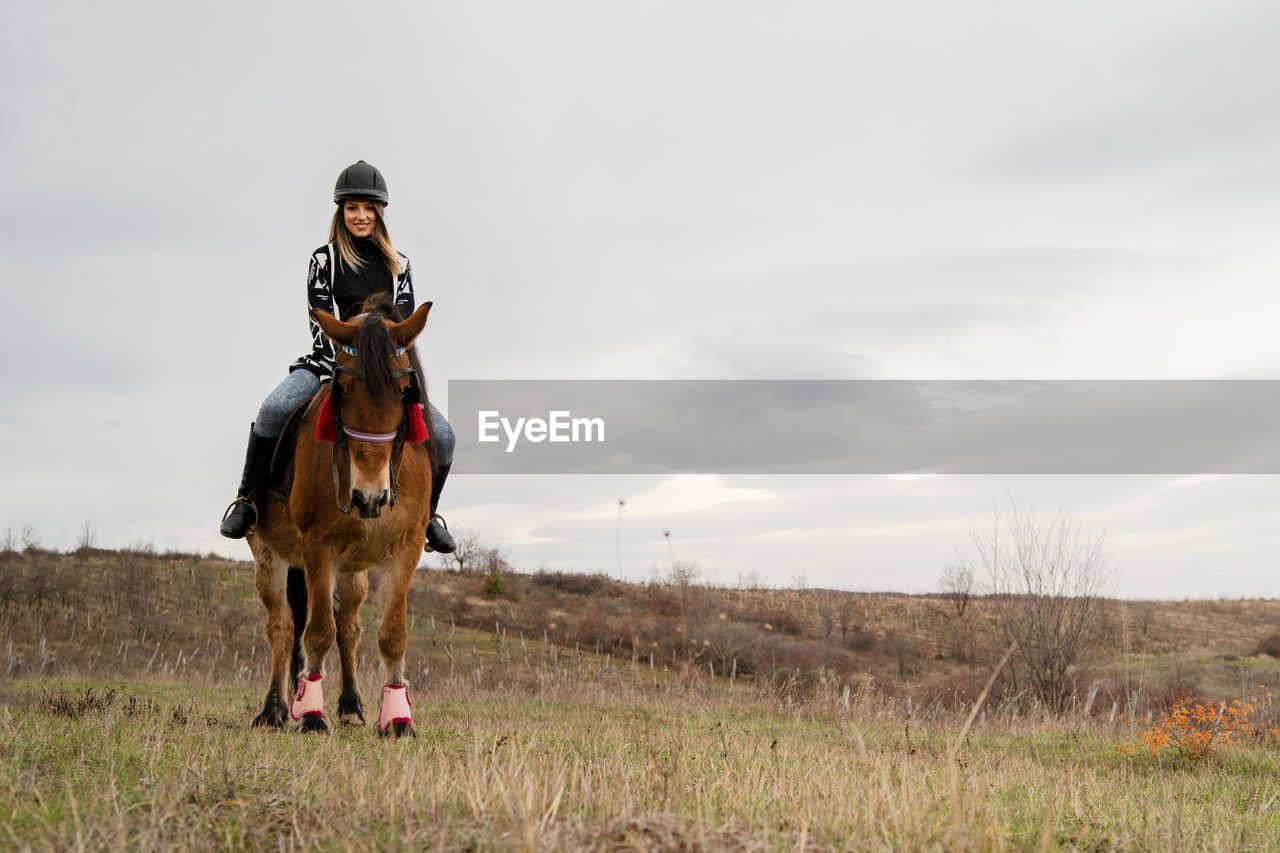 PERSON RIDING HORSE ON FIELD