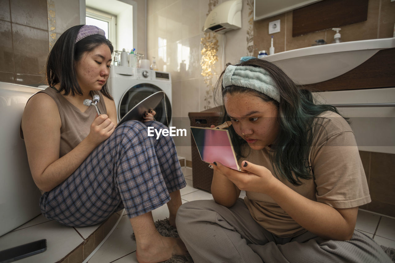 Asian teen beauties begin their morning routine with masking pimples and facial massage in bathroom