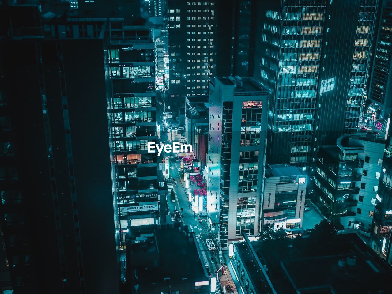 High angle view of illuminated street amidst buildings at night