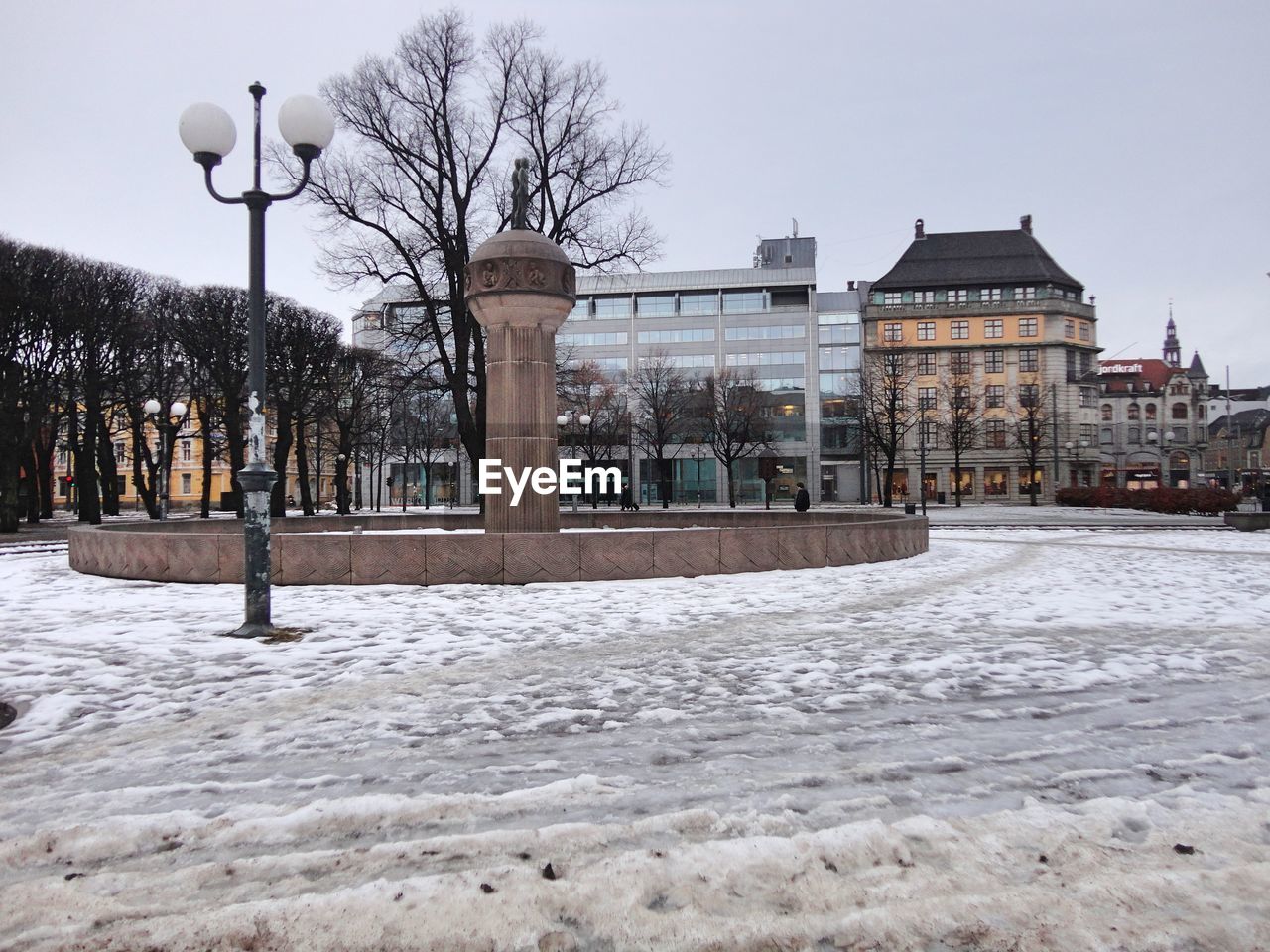 Street by building against sky during winter