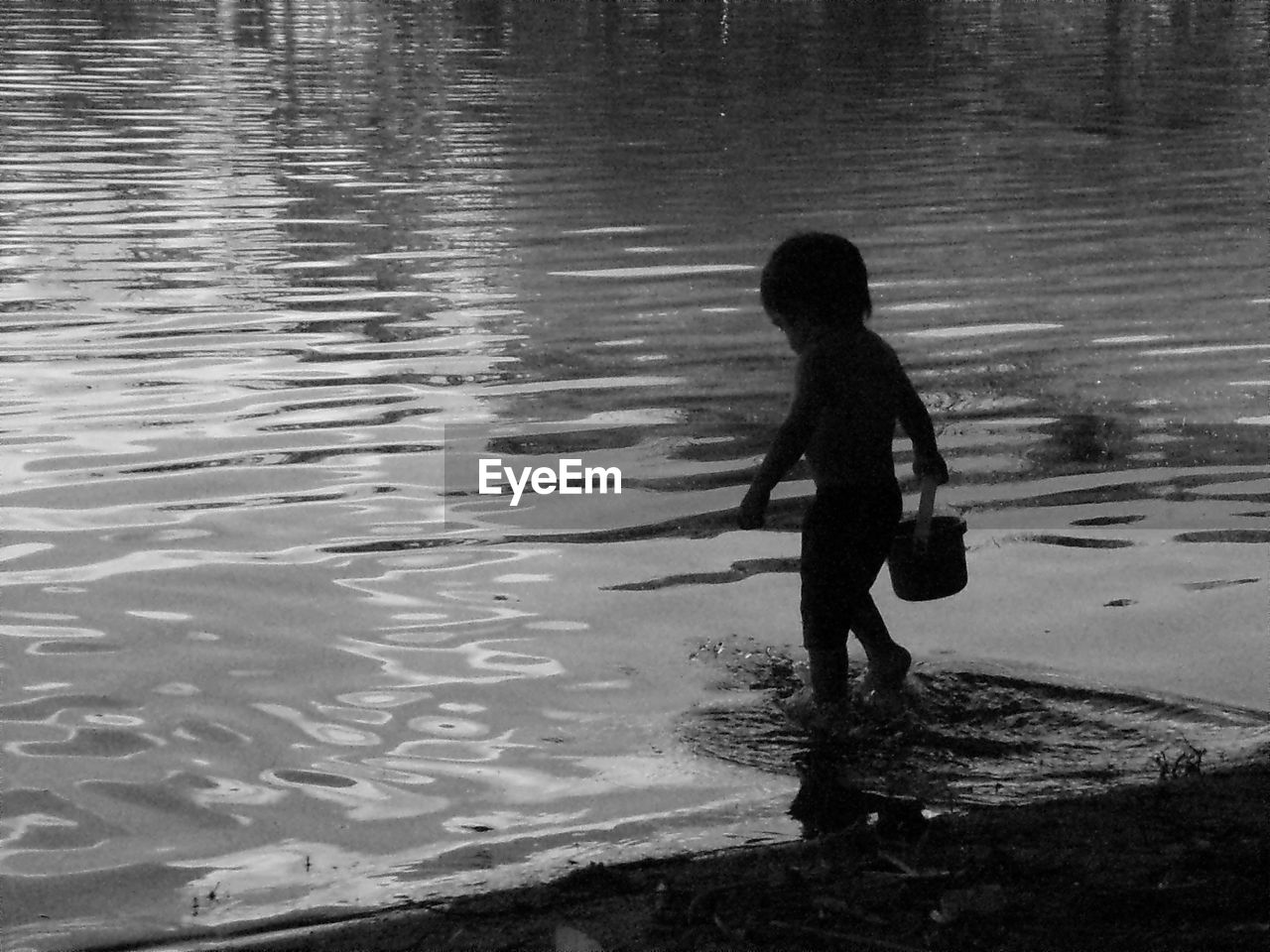 FULL LENGTH OF BOY STANDING ON WATER