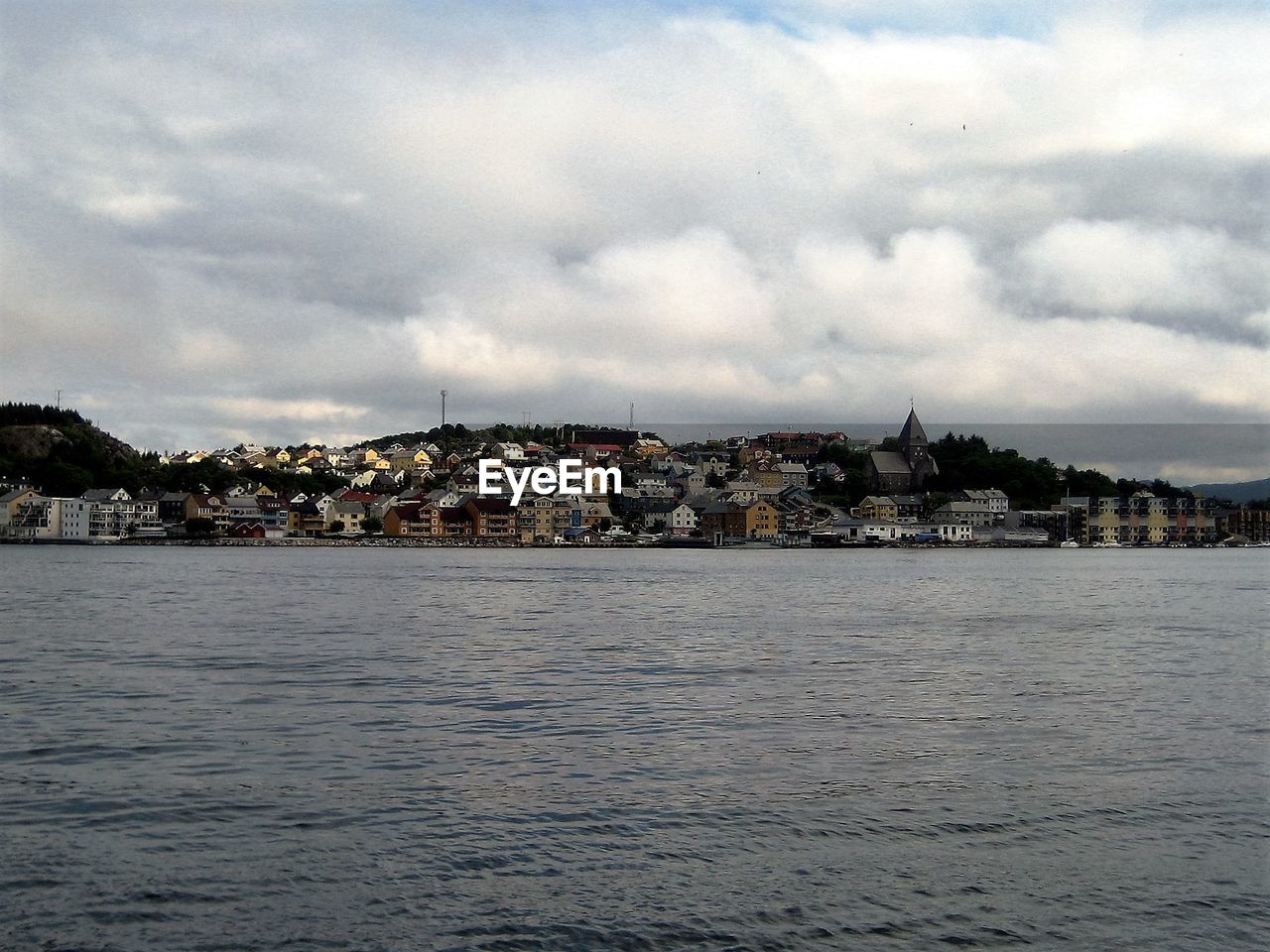 River in town against cloudy sky