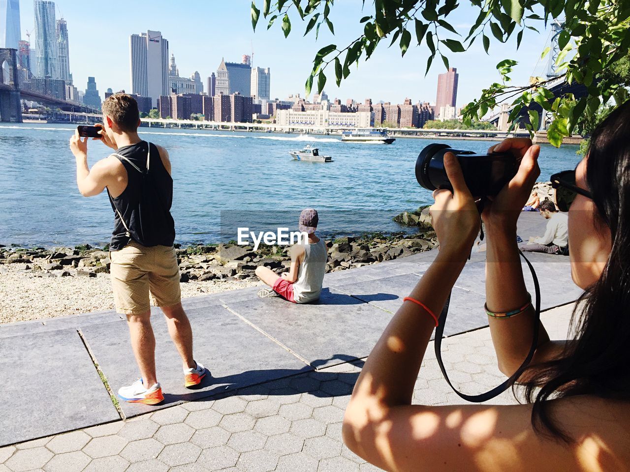 People photographing brooklyn bridge over east river