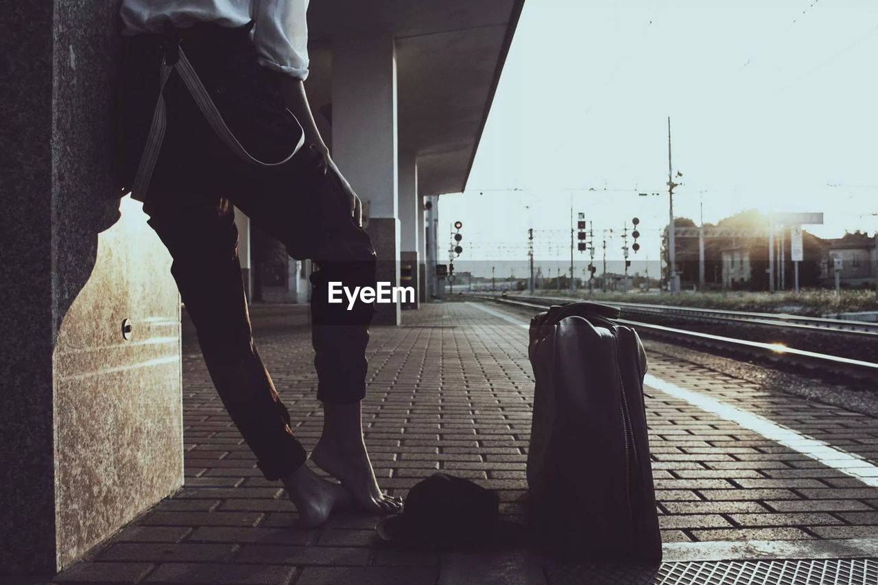 Low section of person waiting on railroad station platform