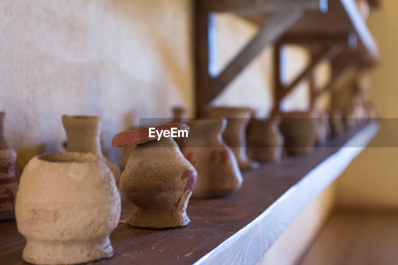 pottery, craft, art, indoors, wood, clay, ceramic, workshop, no people, earthenware, table, creativity, selective focus, food and drink, skill, food, business, focus on foreground, baked, domestic room, terracotta