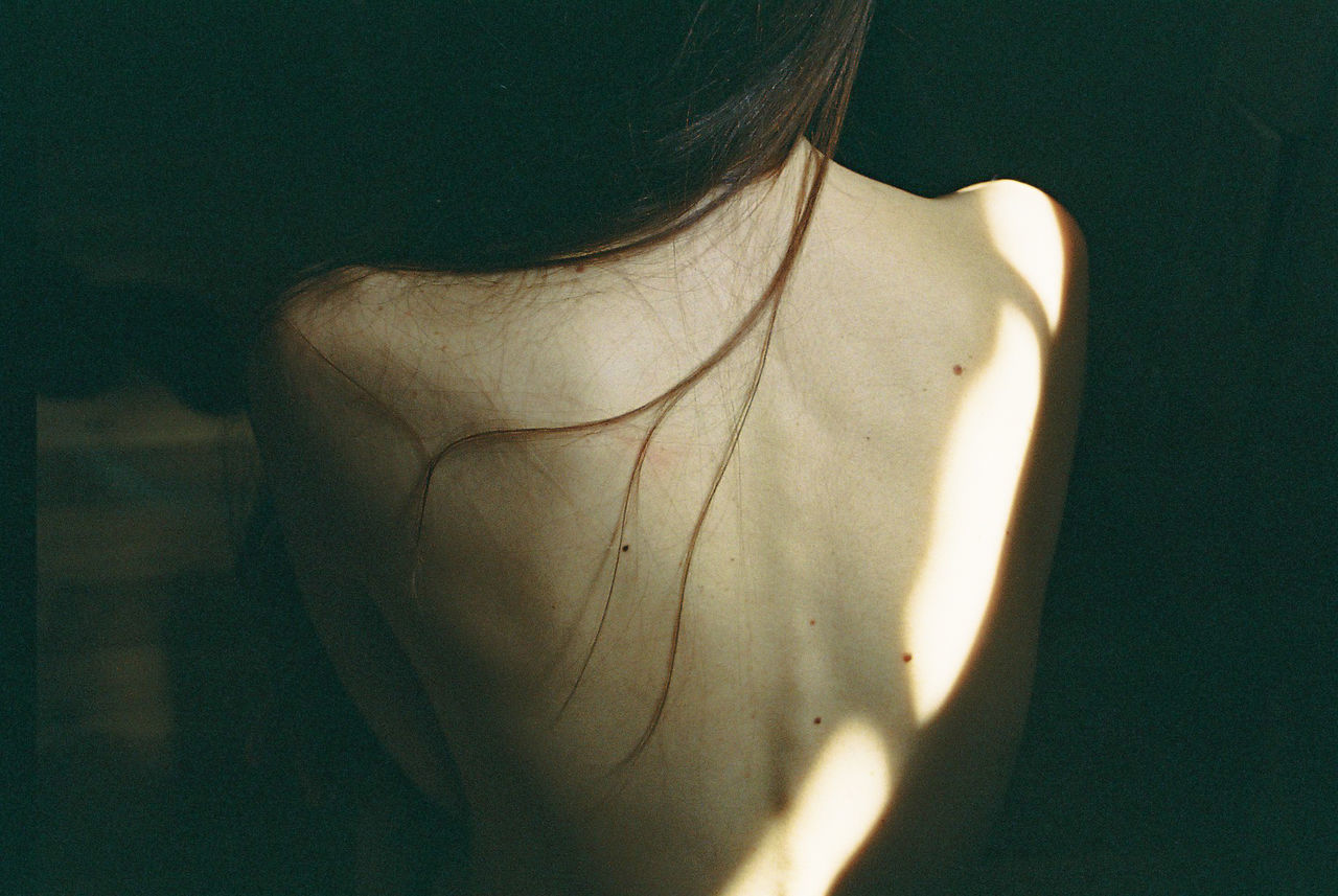 Shirtless woman sitting in darkroom