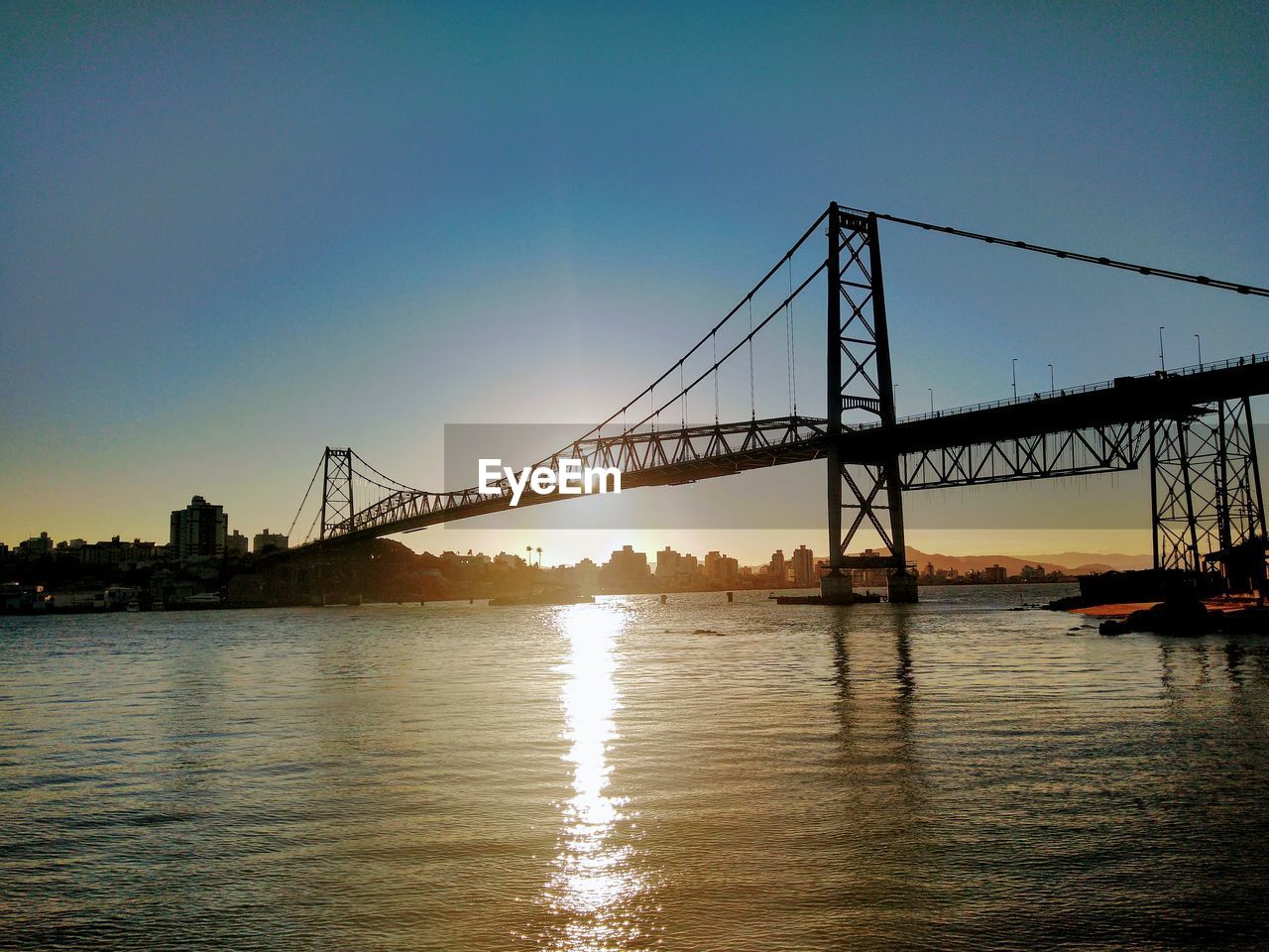 View of bridge over river at sunset