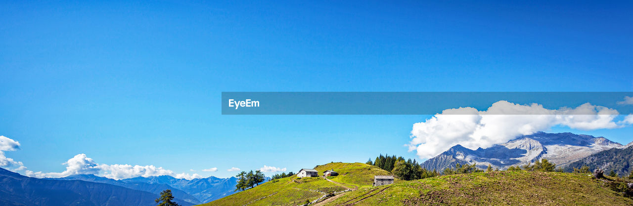 PANORAMIC VIEW OF MOUNTAINS AGAINST BLUE SKY