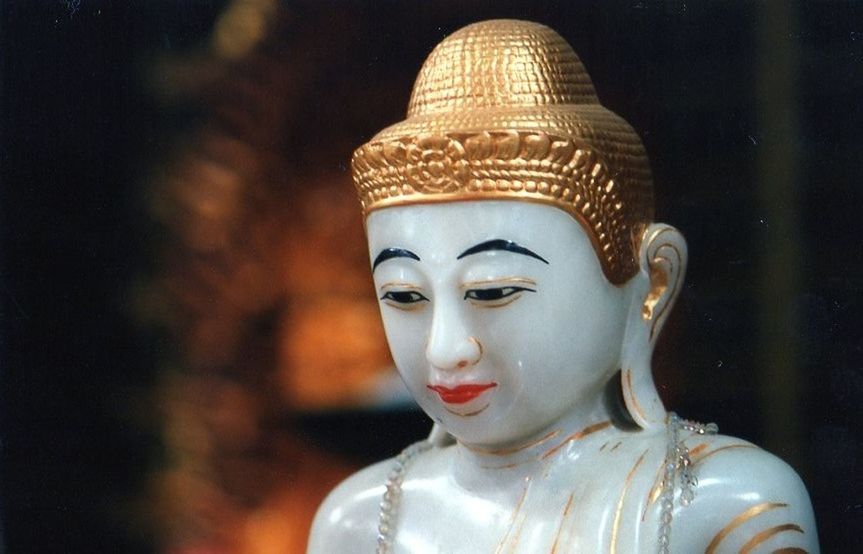 CLOSE-UP OF BUDDHA STATUE AGAINST BLURRED BACKGROUND
