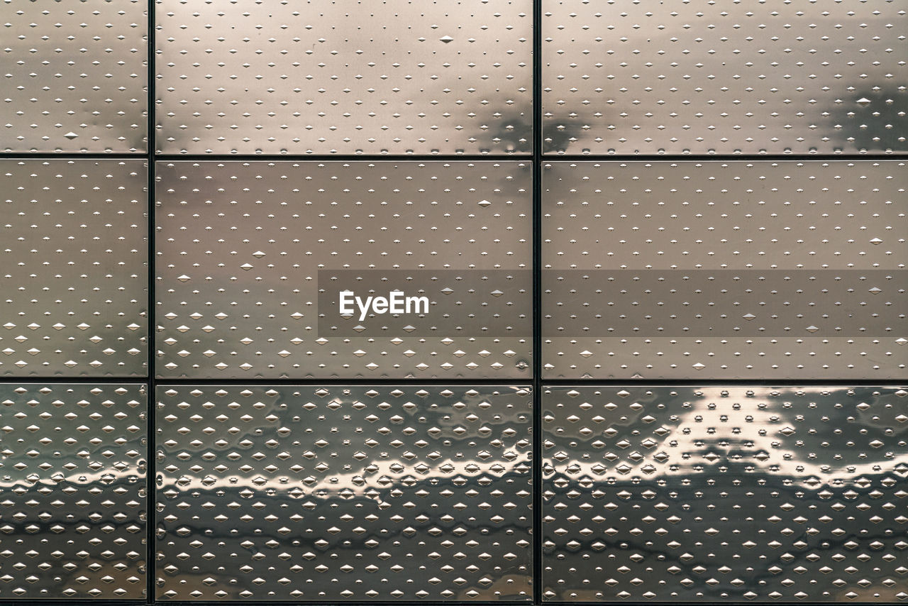 FULL FRAME SHOT OF GLASS WINDOW WITH ILLUMINATED LIGHTS