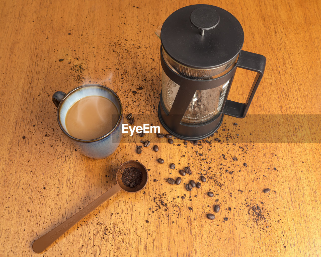 High angle view of coffee with french press and beans on table