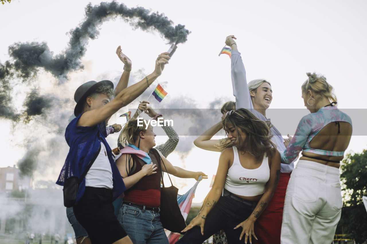 Happy multiracial friends dancing while enjoying at gay pride parade