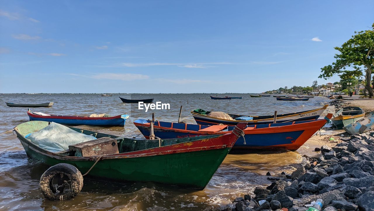 Boats moored in sea against sky