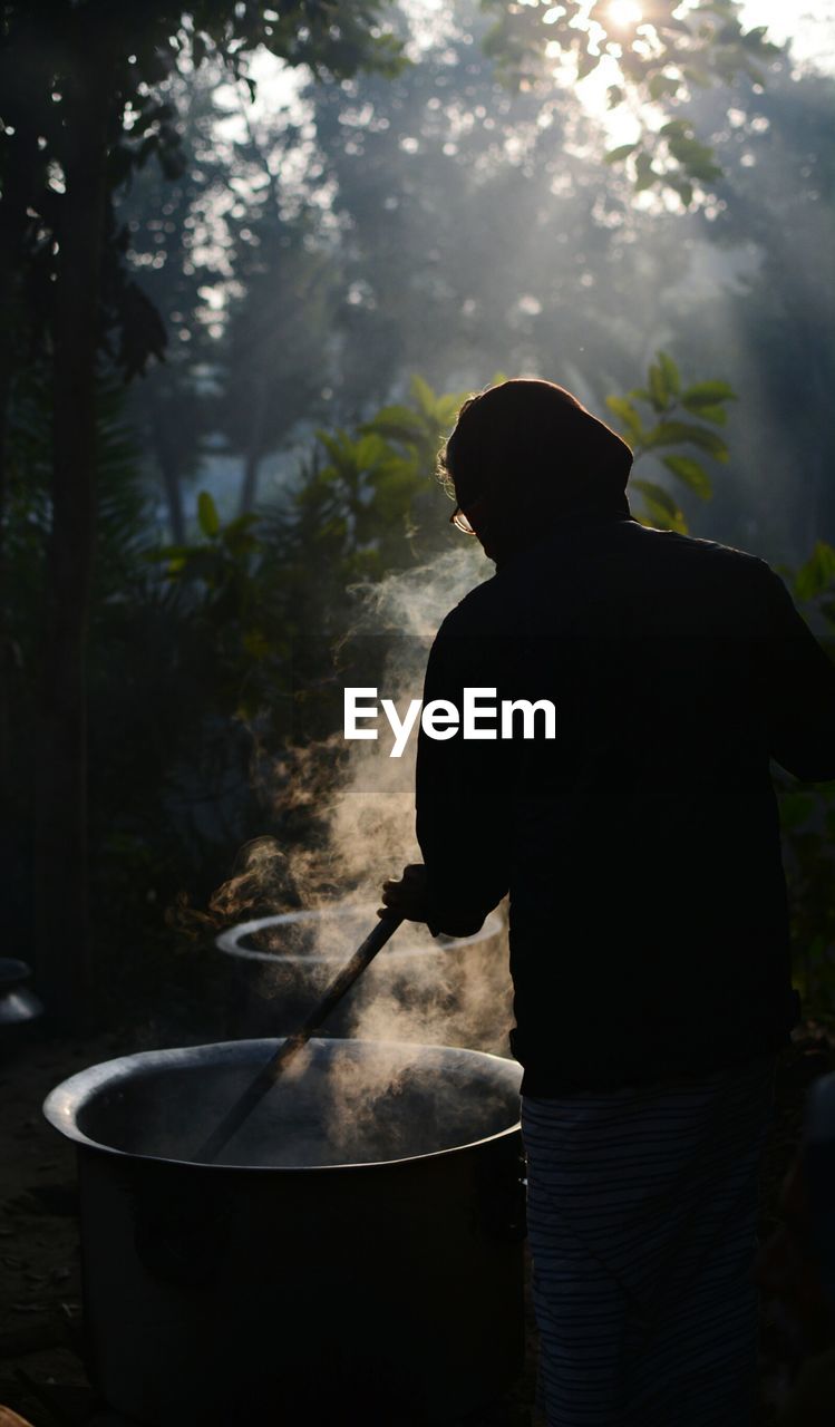 Man preparing food standing amidst trees