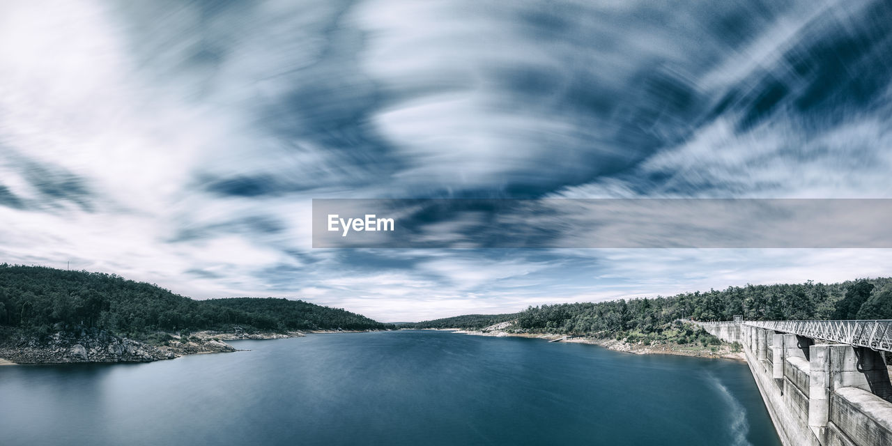 Scenic view of dam against sky with clouds.