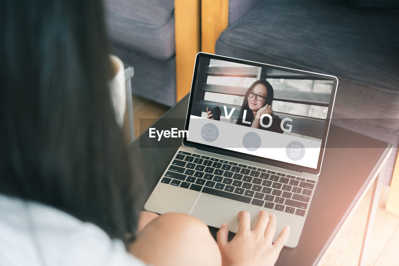 Rear view of woman using laptop in office