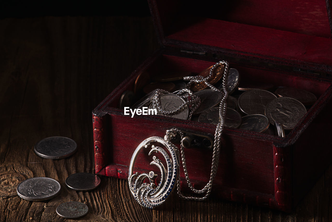 indoors, no people, wood, red, still life, wealth, table, fashion accessory, high angle view, studio shot, box, finance, coin