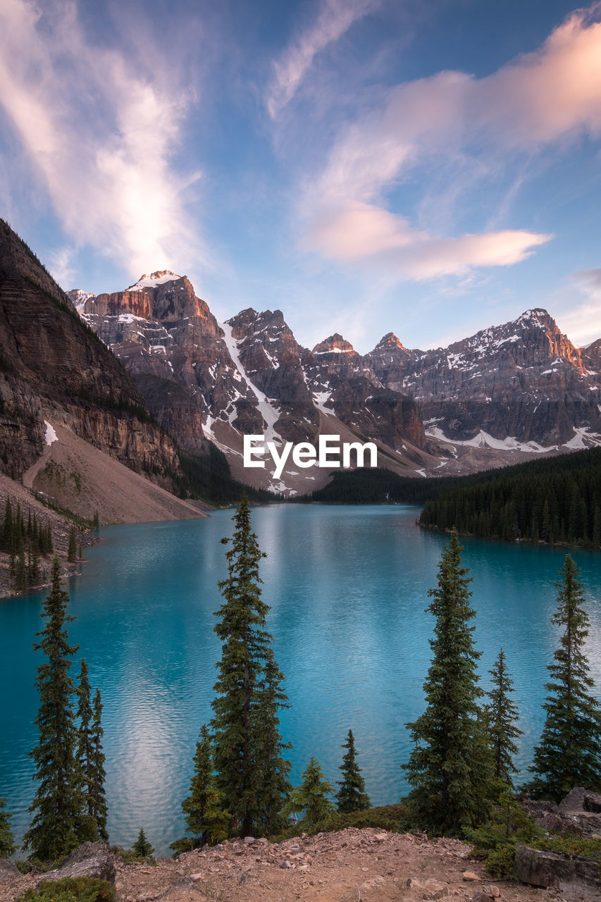 Scenic view of lake by mountains against sky