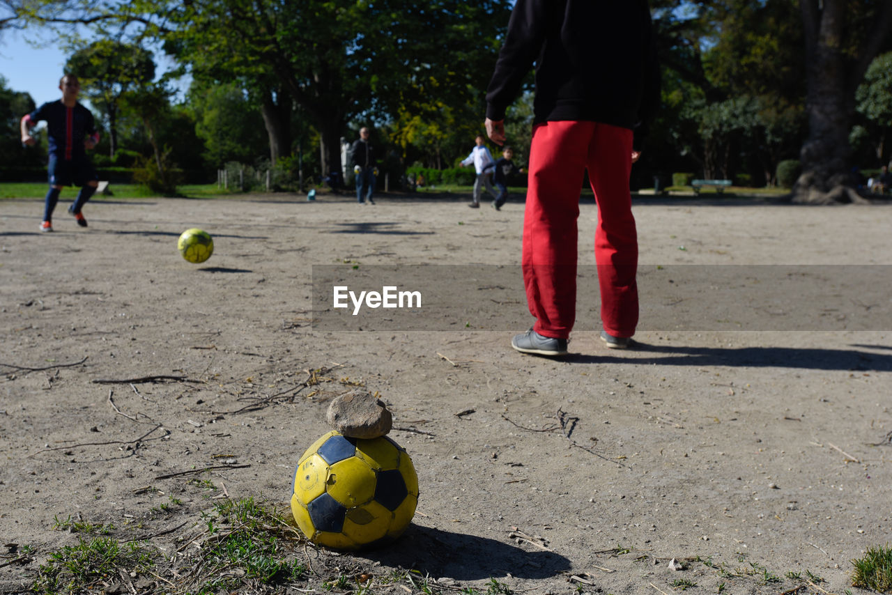 Friends playing soccer on playground