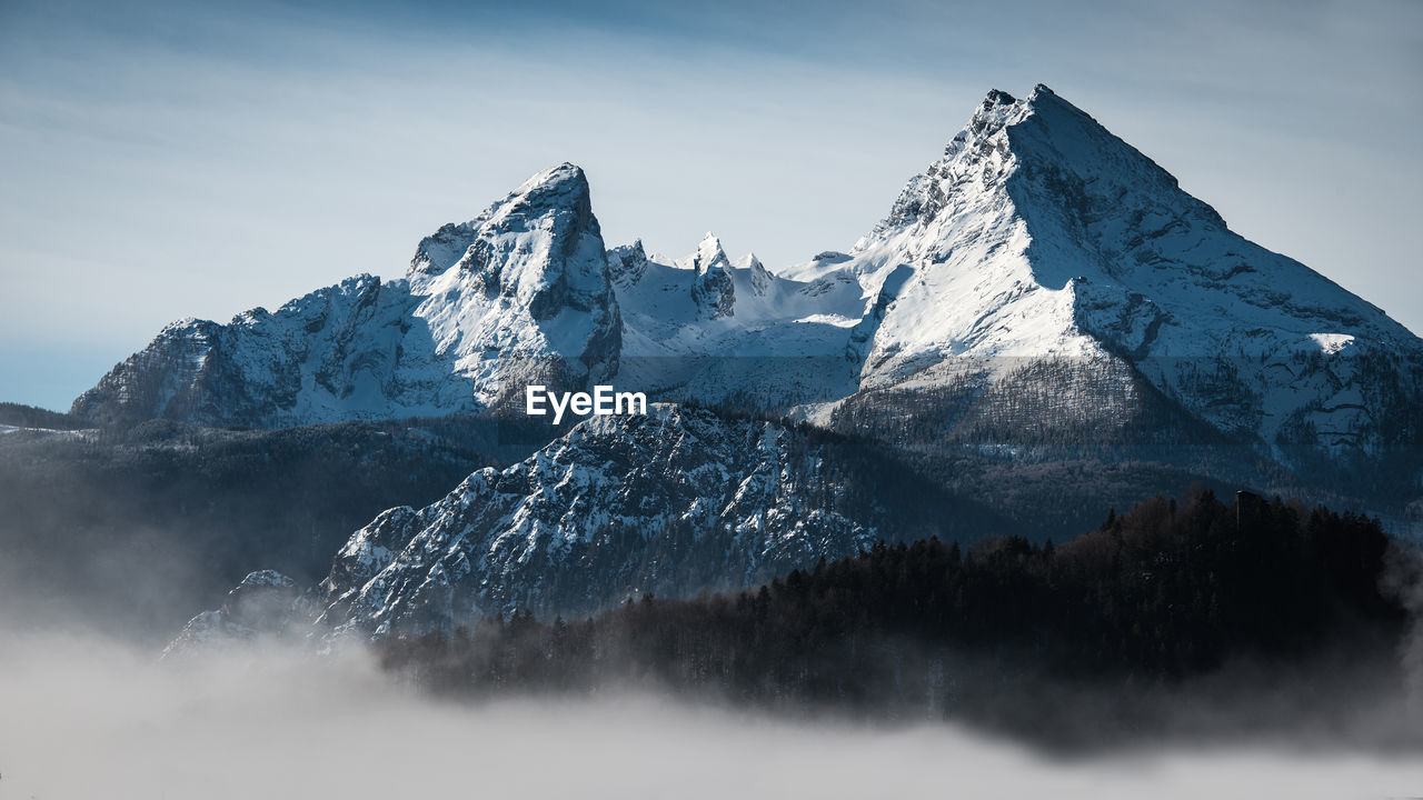 Low angle view of snow mountains against sky