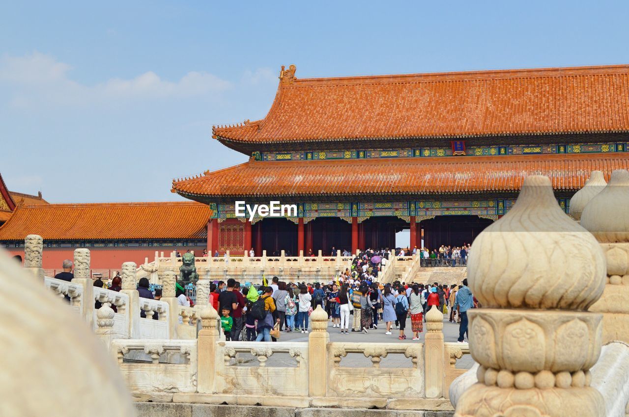 GROUP OF PEOPLE OUTSIDE TEMPLE AGAINST BUILDINGS