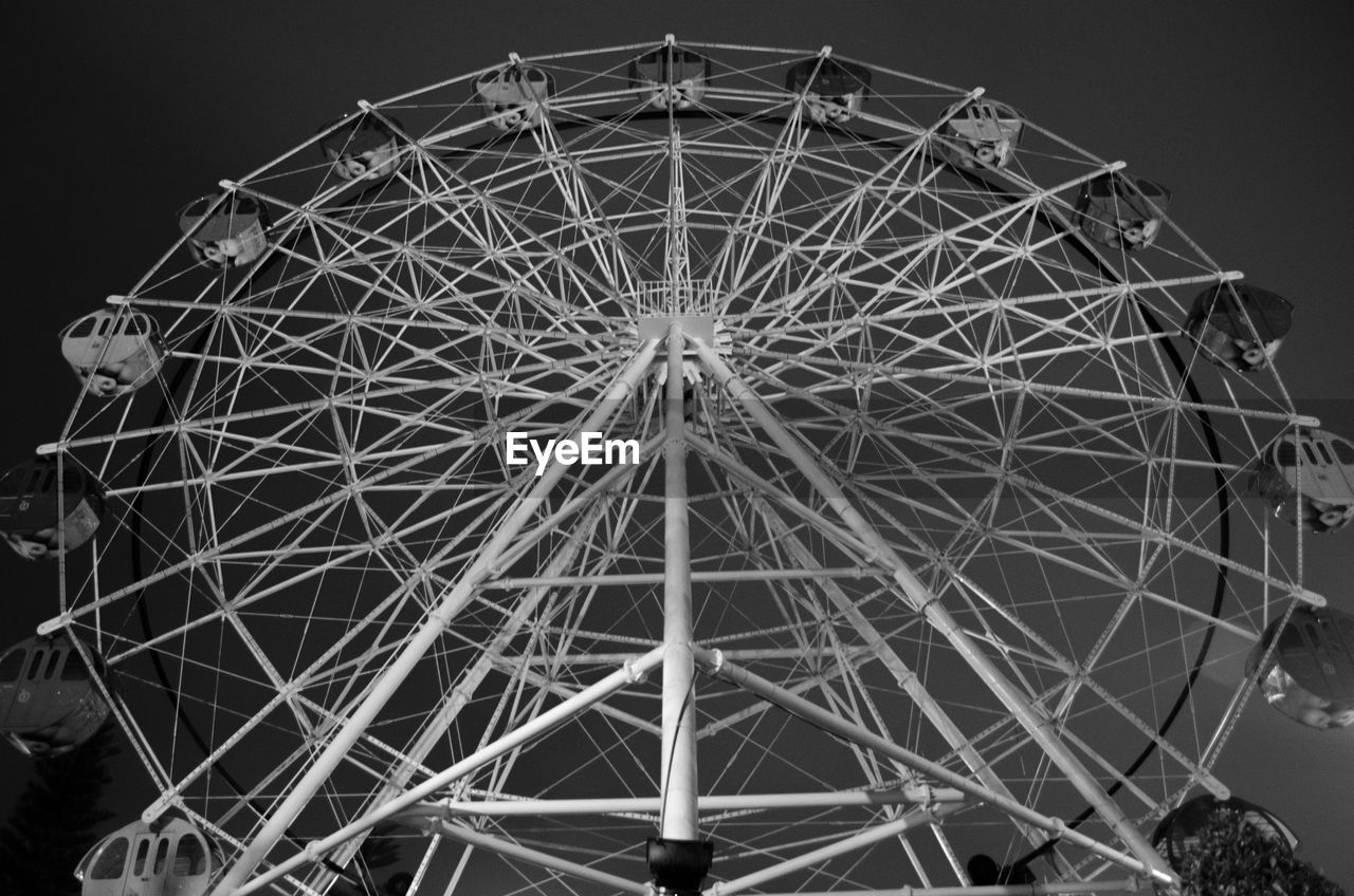 LOW ANGLE VIEW OF ILLUMINATED FERRIS WHEEL AGAINST SKY