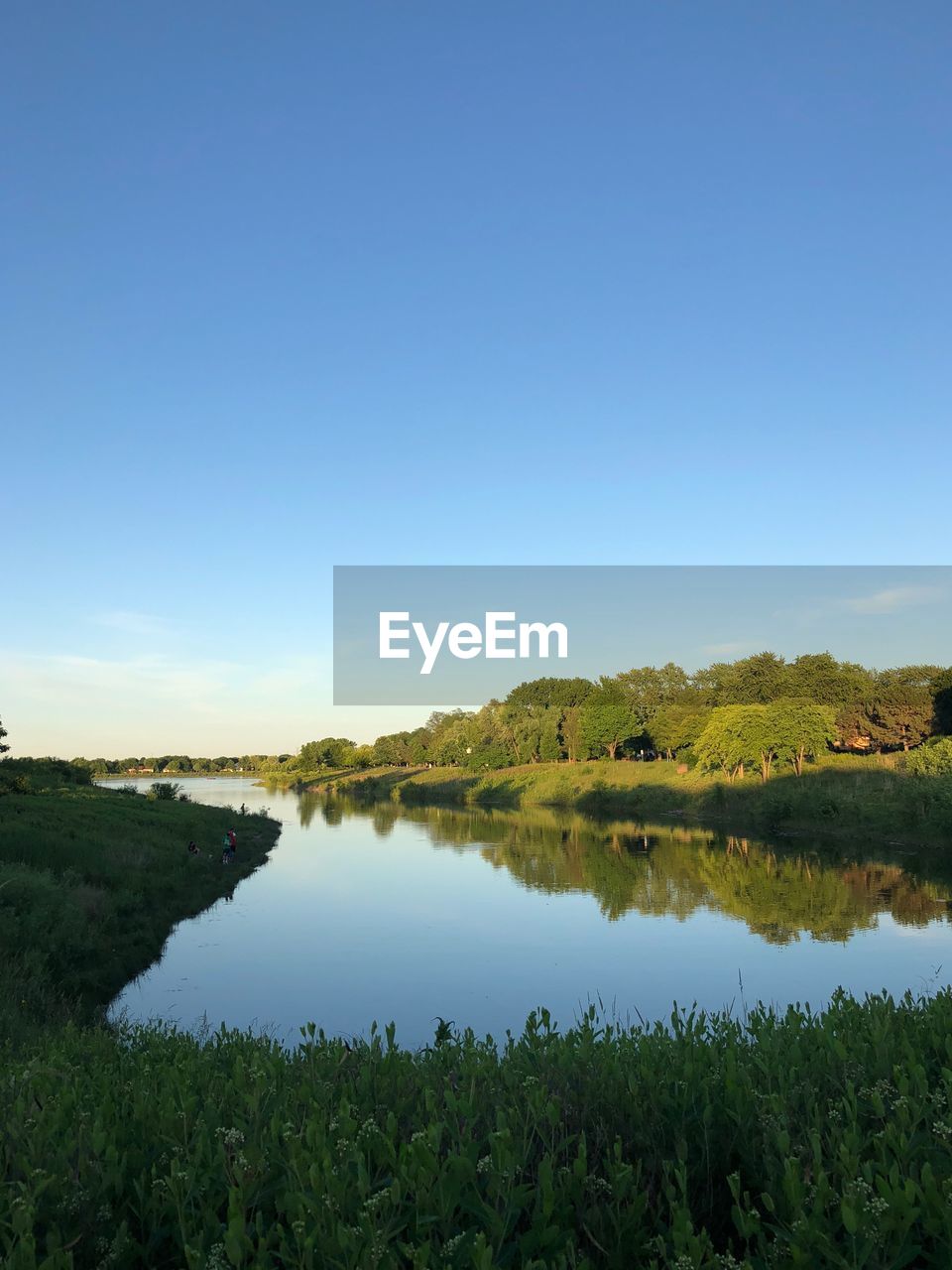 Scenic view of lake against clear blue sky