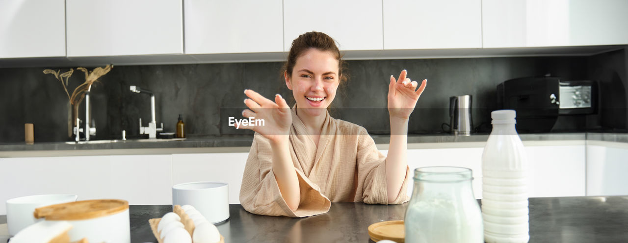 portrait of young woman drinking coffee in kitchen