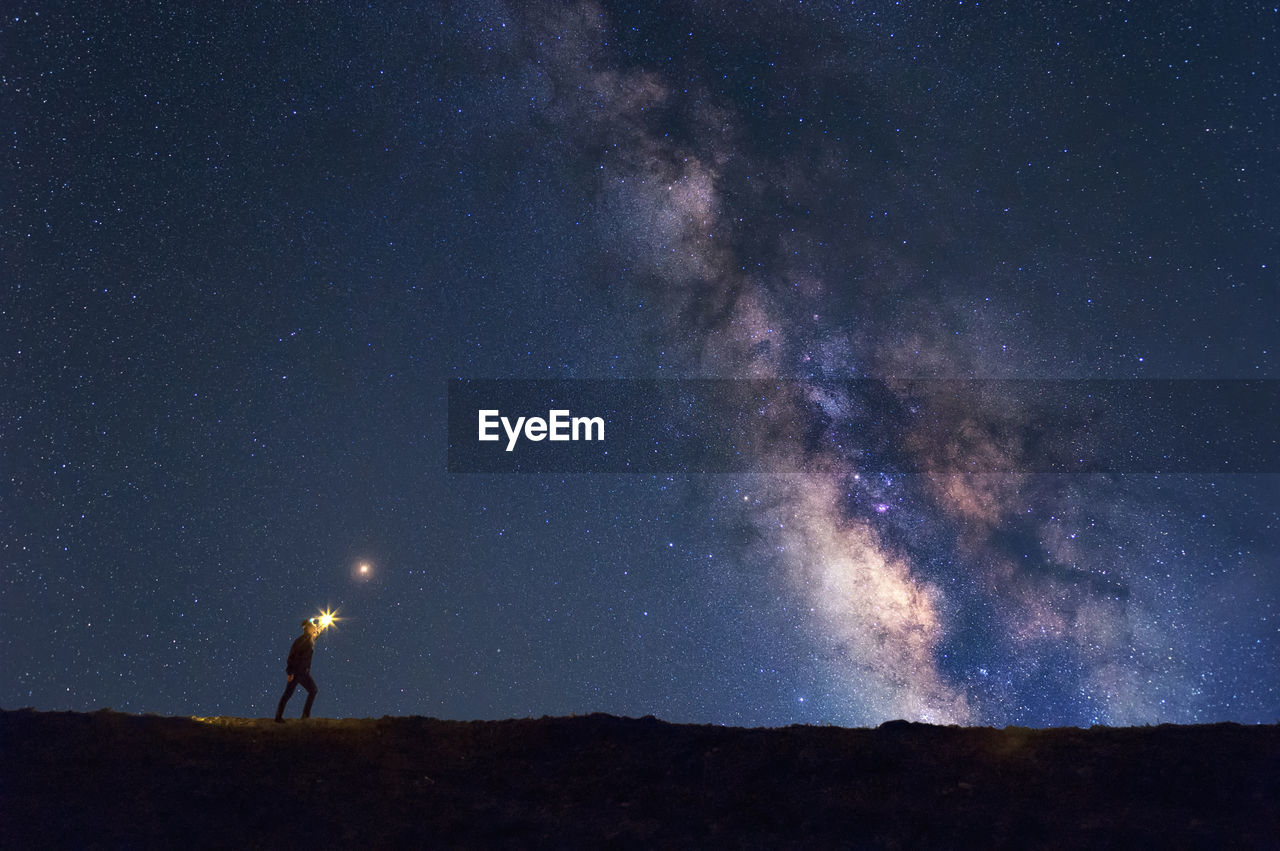 Full length of man standing against star field at night