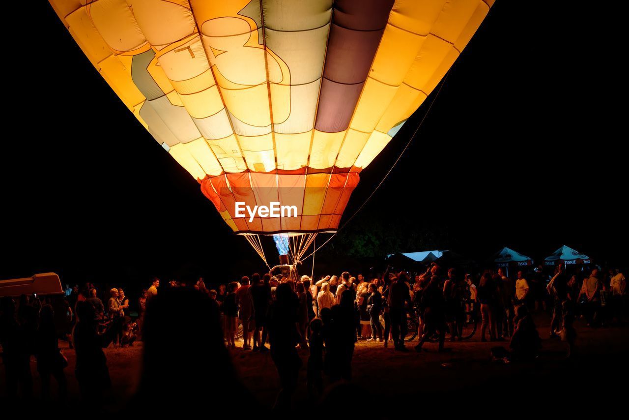 low angle view of illuminated hot air balloons at night