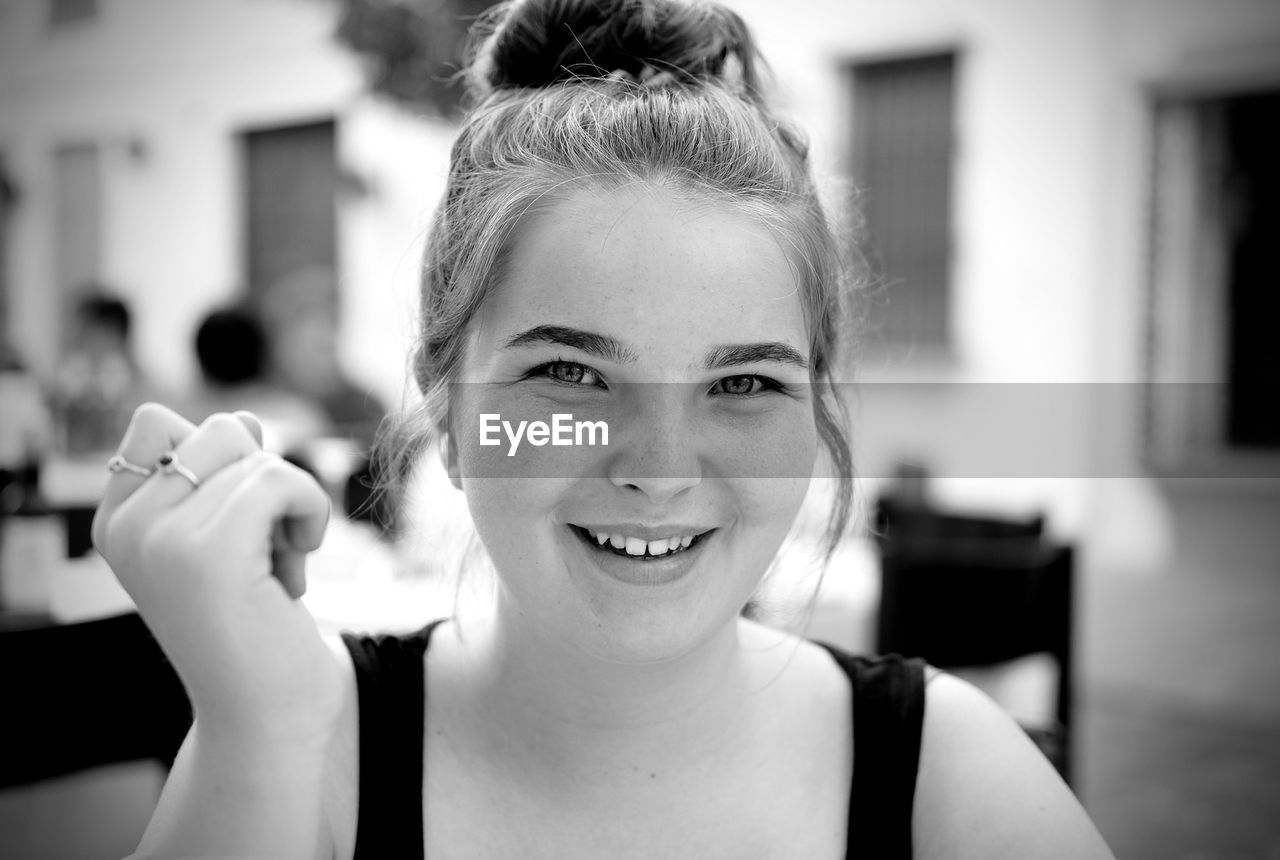 Close-up portrait of smiling girl in cafe