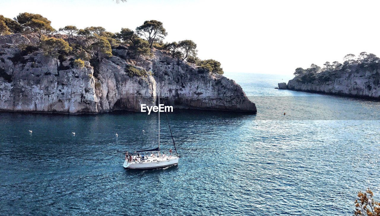 BOATS SAILING IN SEA AGAINST CLEAR SKY