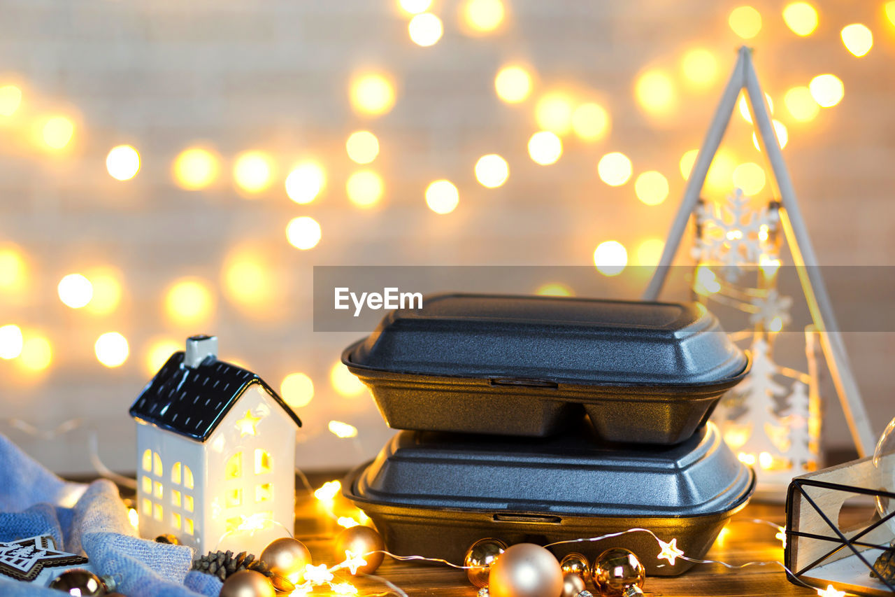 CLOSE-UP OF ILLUMINATED CHRISTMAS DECORATIONS ON TABLE