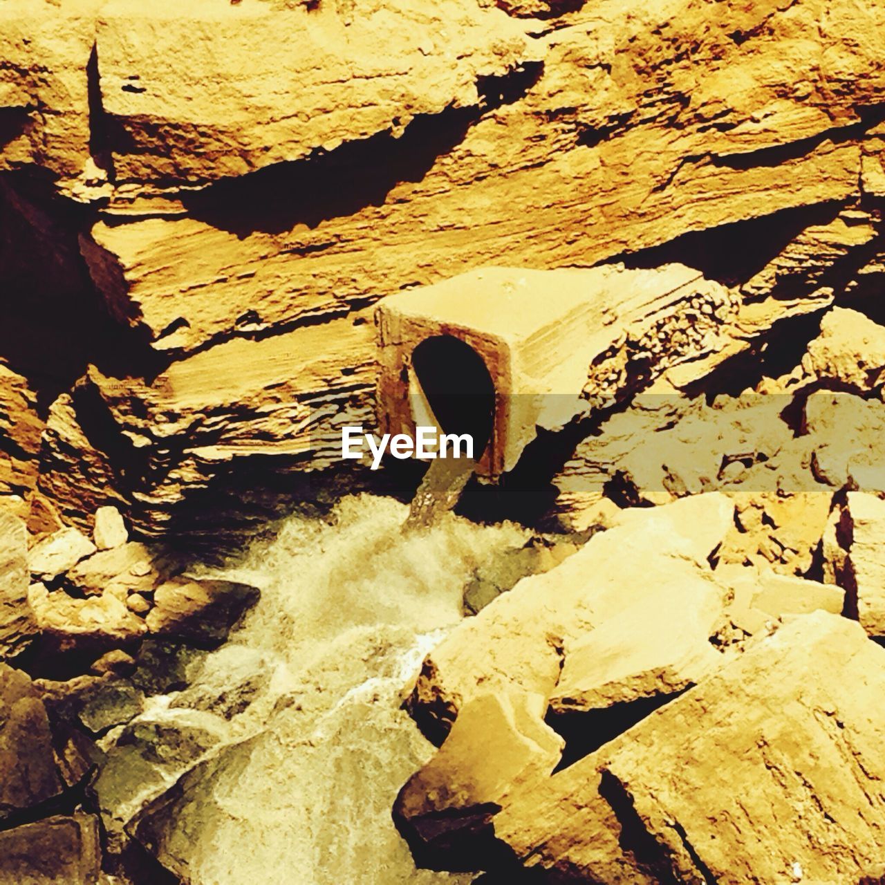 Close-up of water outlet amid rocks