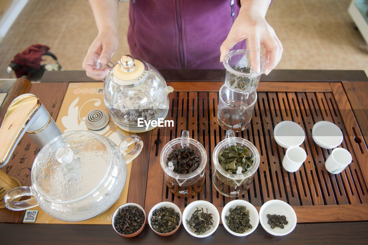 Midsection of person making tea at home