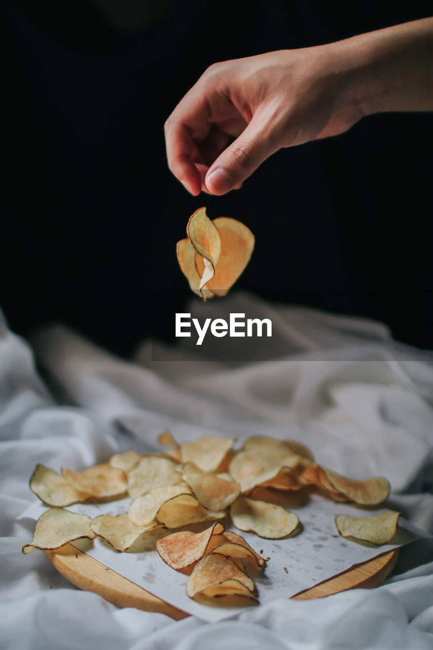 High angle view of hand holding leaves on table