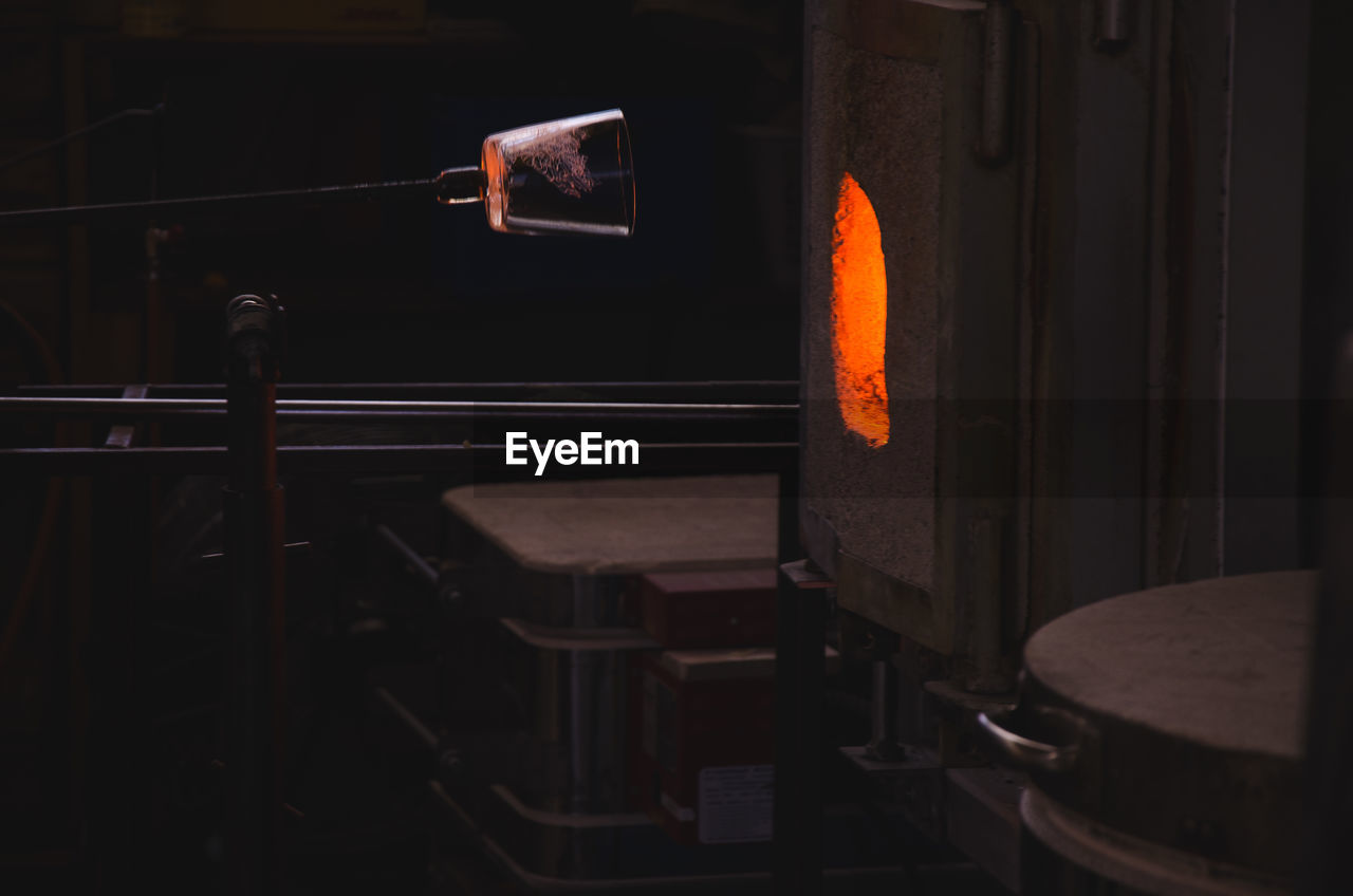 Close-up of glass blower by furnace in factory