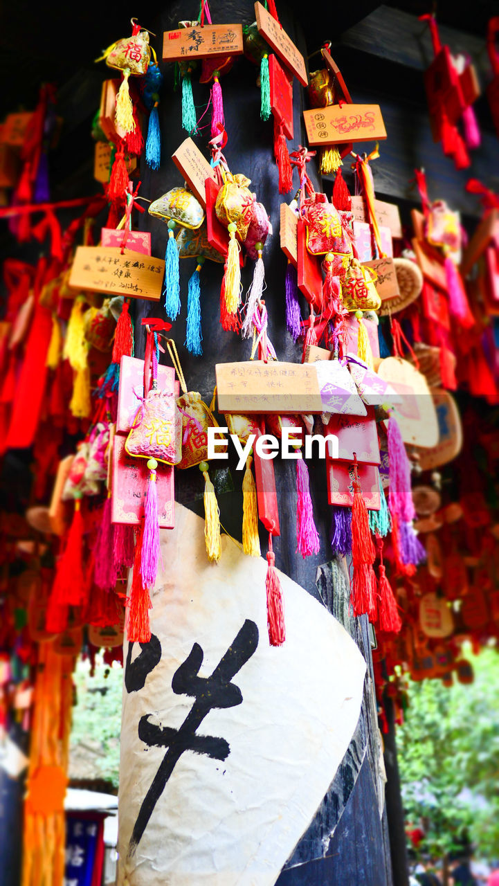 CLOSE-UP OF MULTI COLORED DECORATION HANGING OUTSIDE MOSQUE