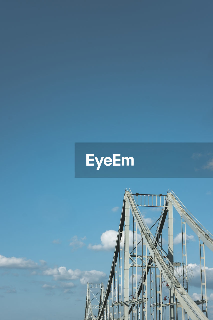 LOW ANGLE VIEW OF SUSPENSION BRIDGE AGAINST CLEAR BLUE SKY