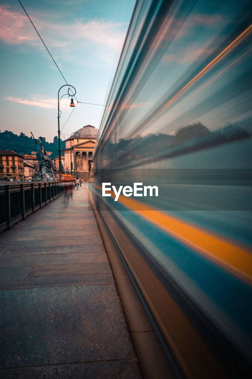 Blurred motion of train in city against sky