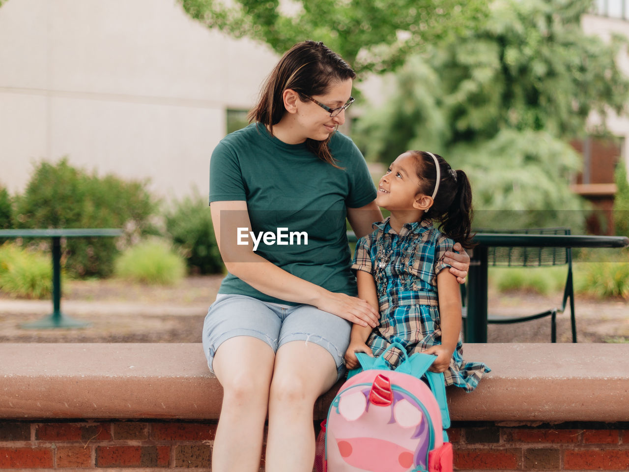 Young millennial mother sending daughter off back to school